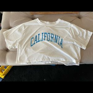 Crop-top with white color and blue letters that say “CALIFORNIA”. Size Large.